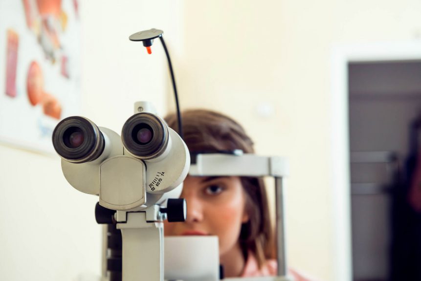 portrait cute caucasian female patient sitting optometrist office waiting start procedure check her vision with microbioscope sitting yellow wall ophthalmology concept